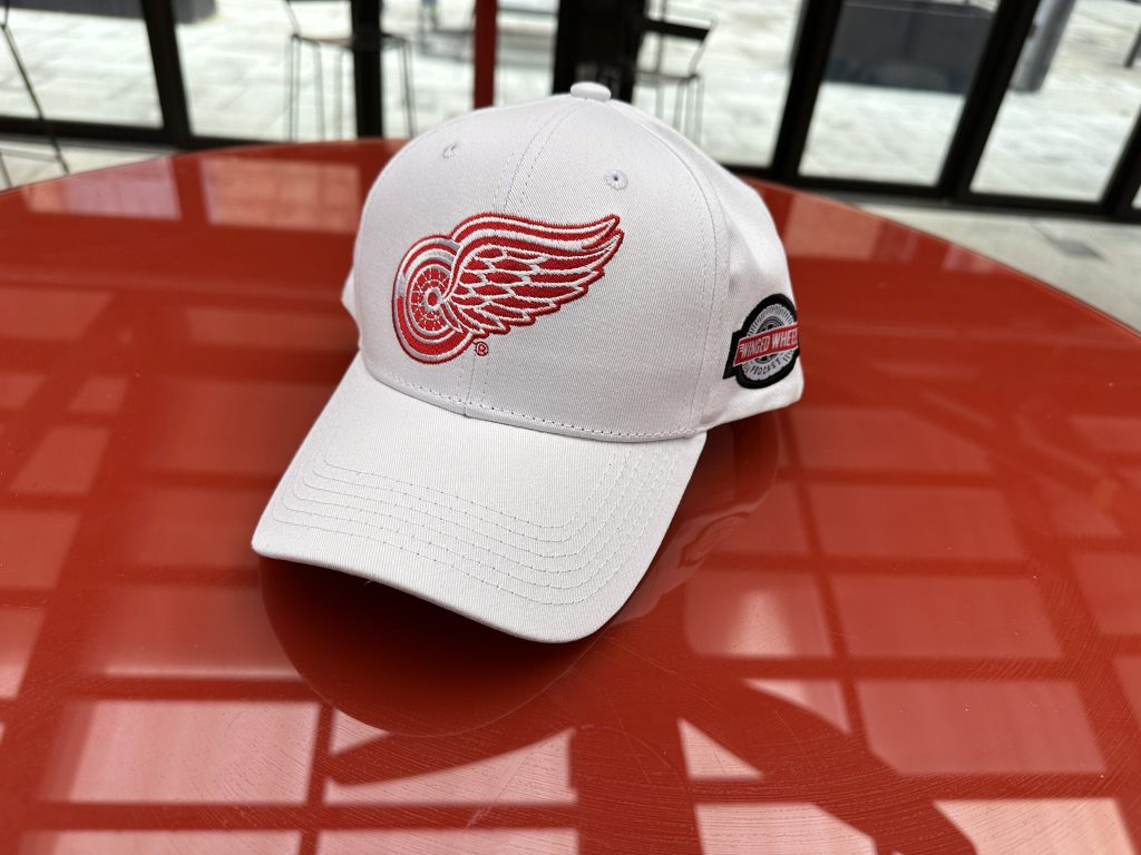 White cap photographed at venue — front and side logos